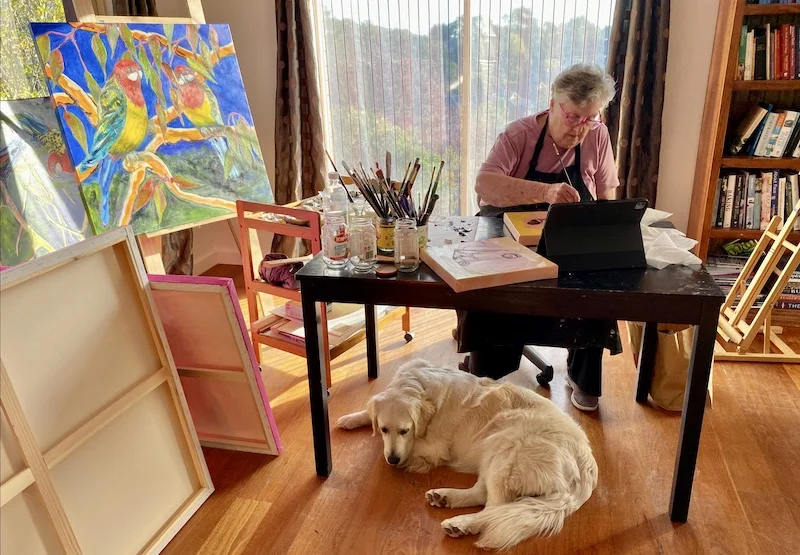 Heather at work at table with dog underneath